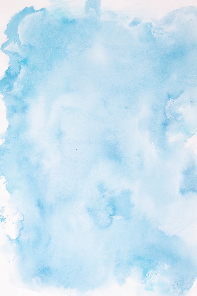 Soft abstract blue watercolor art on a white surface, ideal for backgrounds.